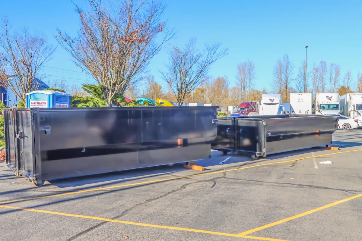 Professional dumpster rental service with roll-off container on residential driveway in St. Stephens